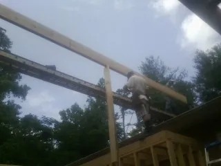 Carpenter setting a ridge beam over a new addition frame — Ice Dam Removal by Roofing Brothers in Negley