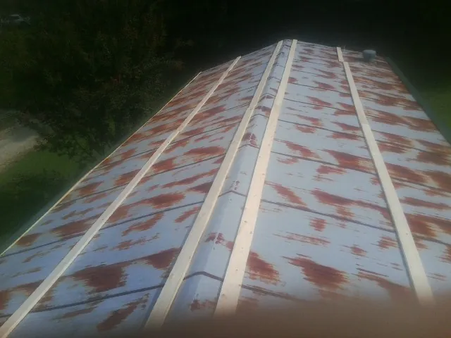 Rusted metal roof panels with new wood purlins before replacement — Storm Damage Roof Repair in Negley by Roofing Brothers